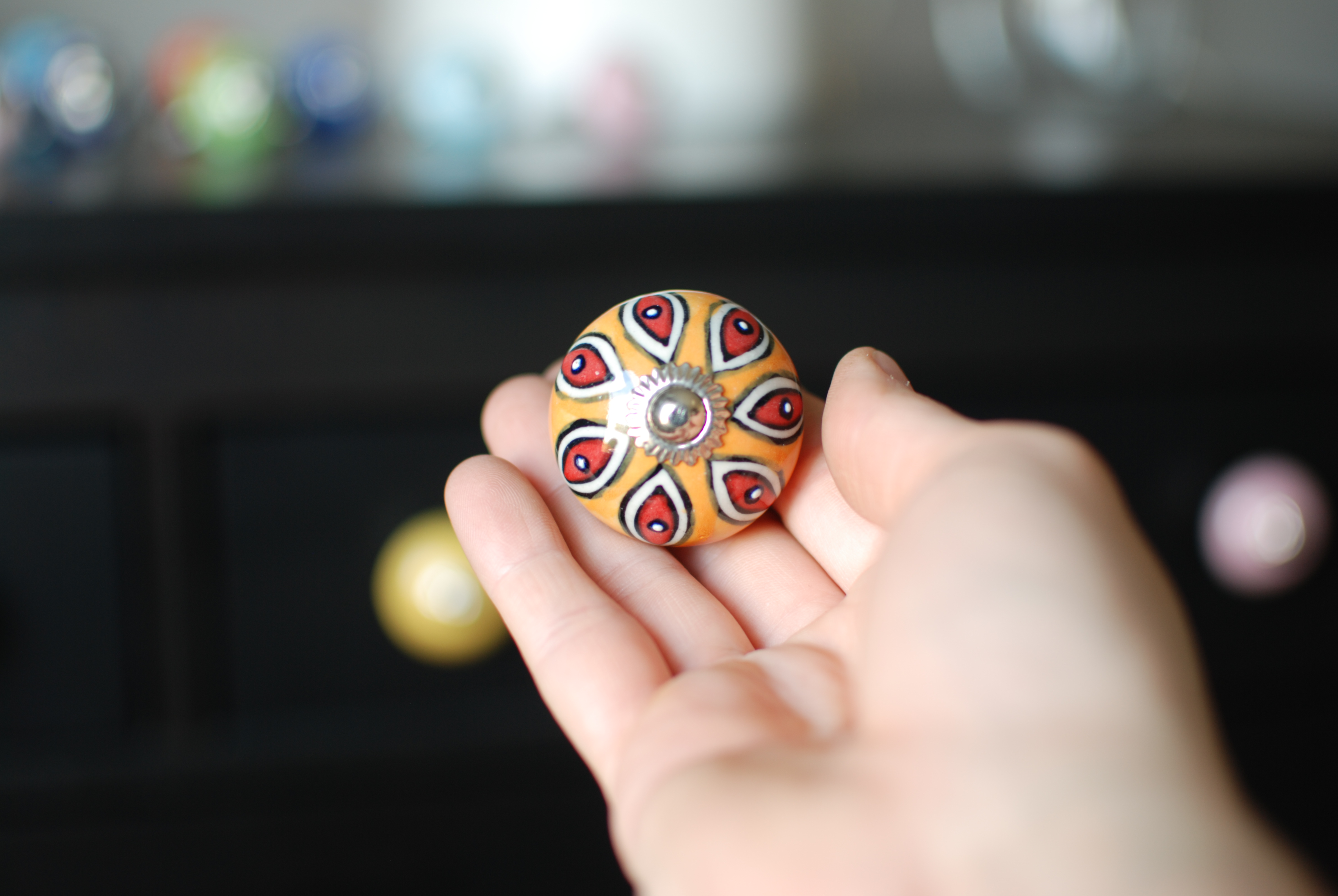 Úchytka s oranžovo-červeným ornamentom