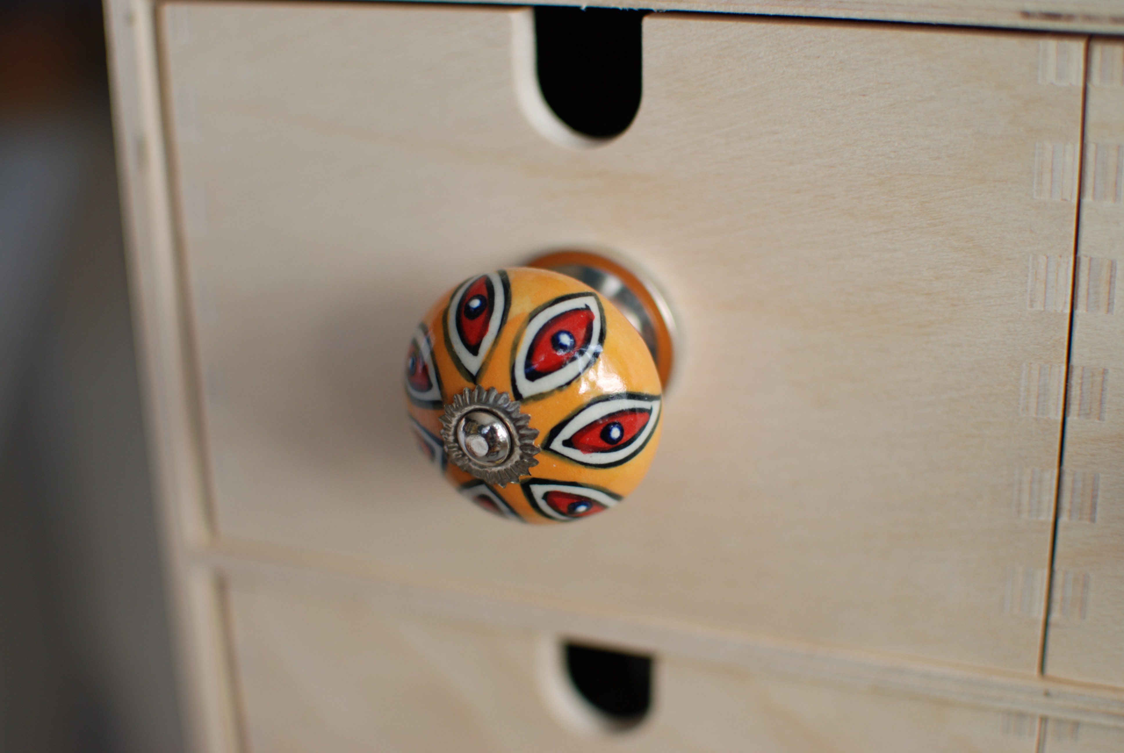 Úchytka s oranžovo-červeným ornamentom