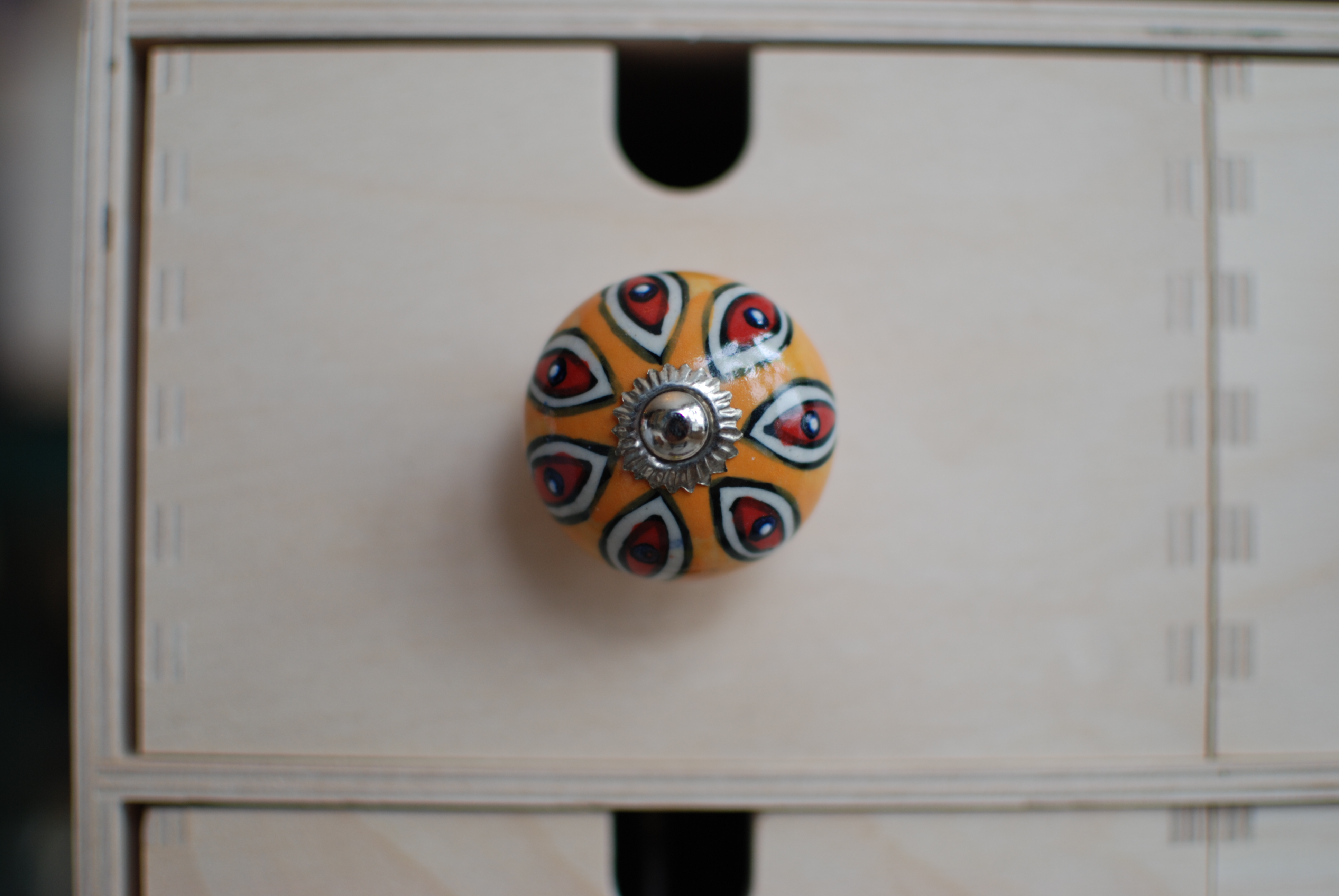 Úchytka s oranžovo-červeným ornamentom